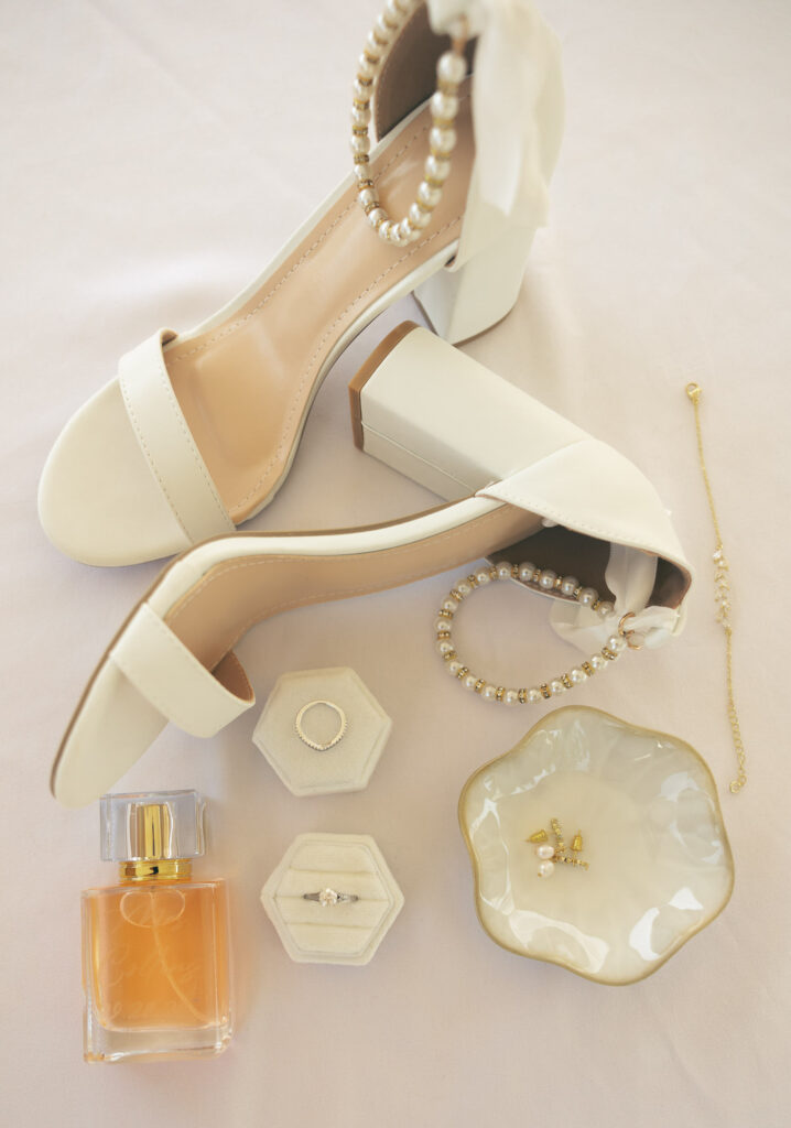 the bridal details with rings, perfume, and her shoes