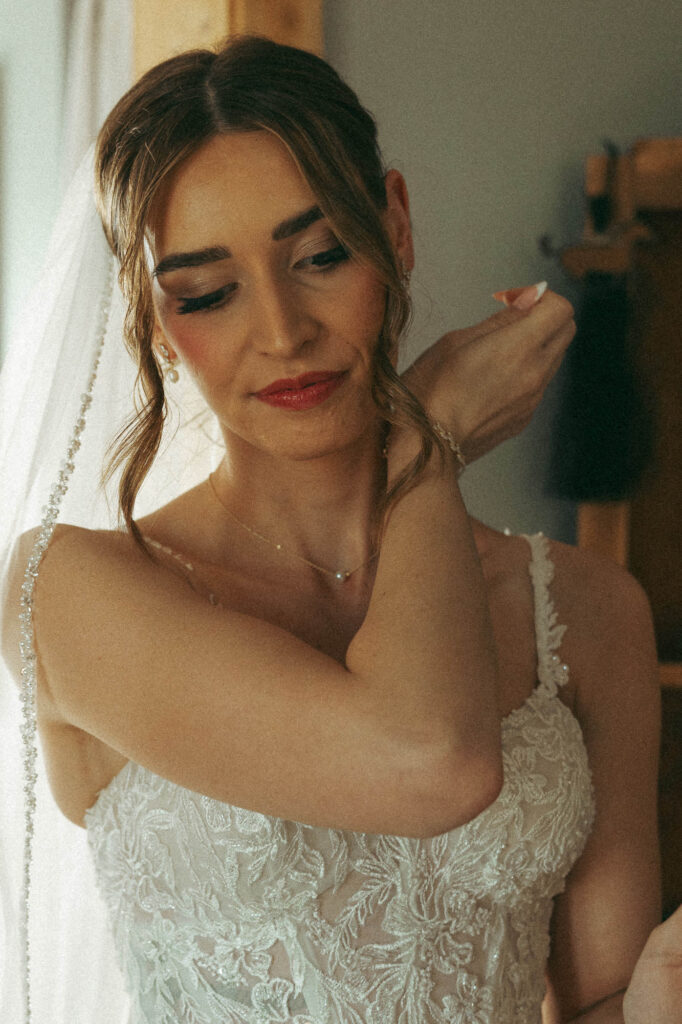 bride putting her perfume on before she walks down the aisle