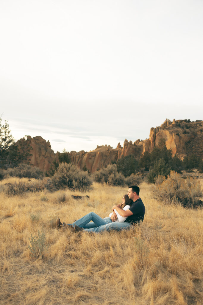 engaged couple reminiscing at smith rock state park