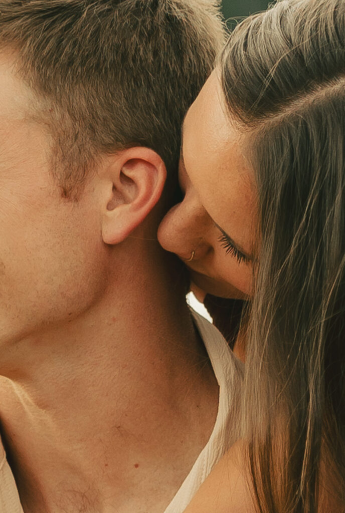 close up of girl kissing man's neck