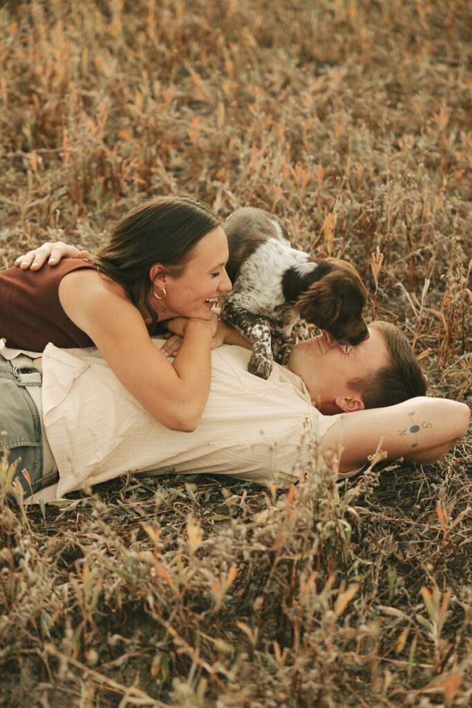 couple and their puppy laying down