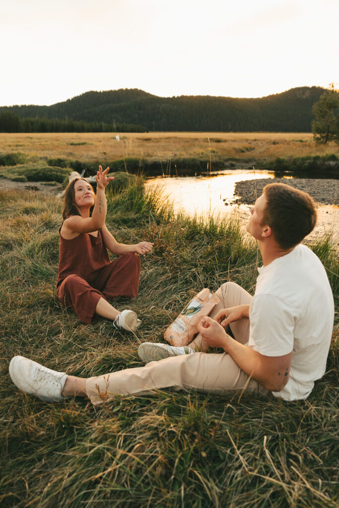 couple throwing popcorn at engagement shoot at sparks lake