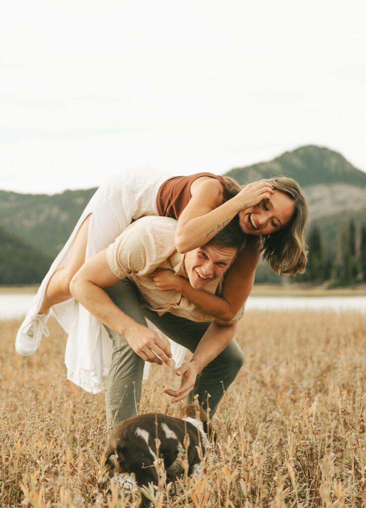 couple in piggy back laughing at each other 