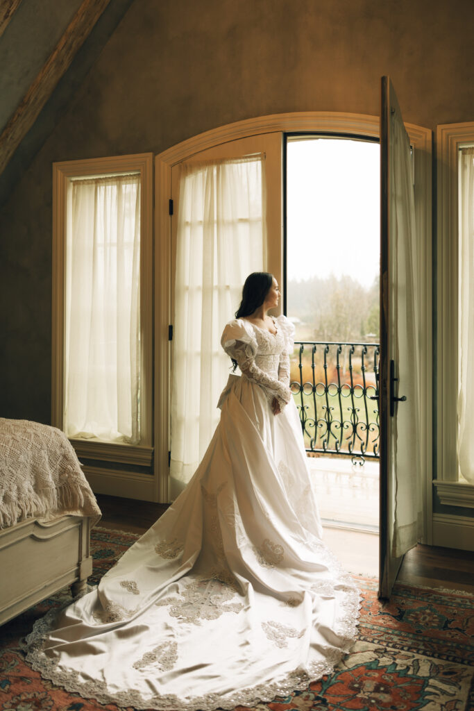 bride leaning on door and looking over venue grounds