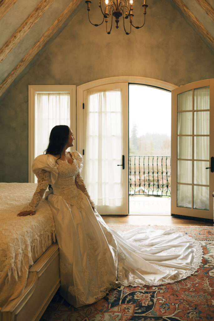 bride lounging on bed as she looks outside