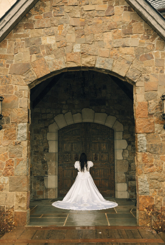 bride posed in front of large door facing away