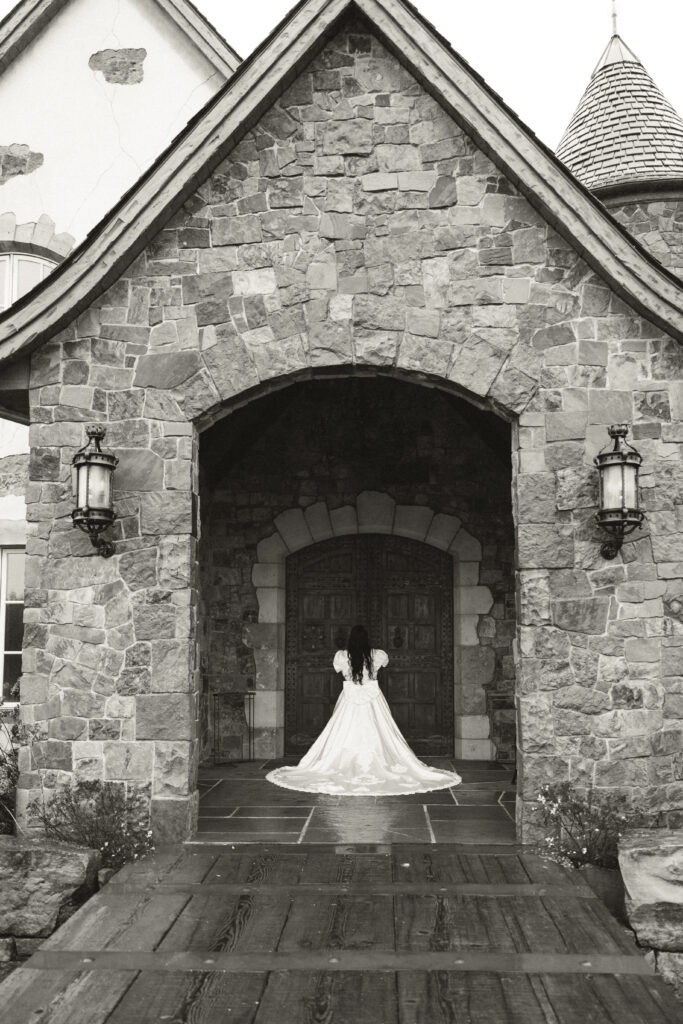 bride about to open doors to chateau