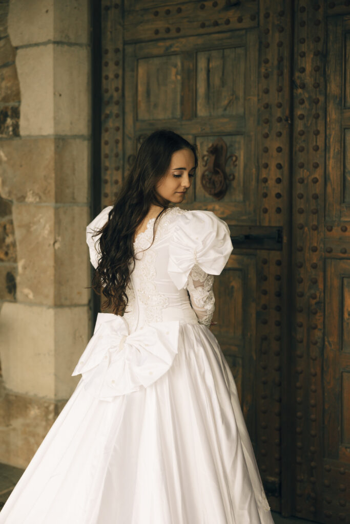 bridal portrait of her facing away and looking back down her shoulder