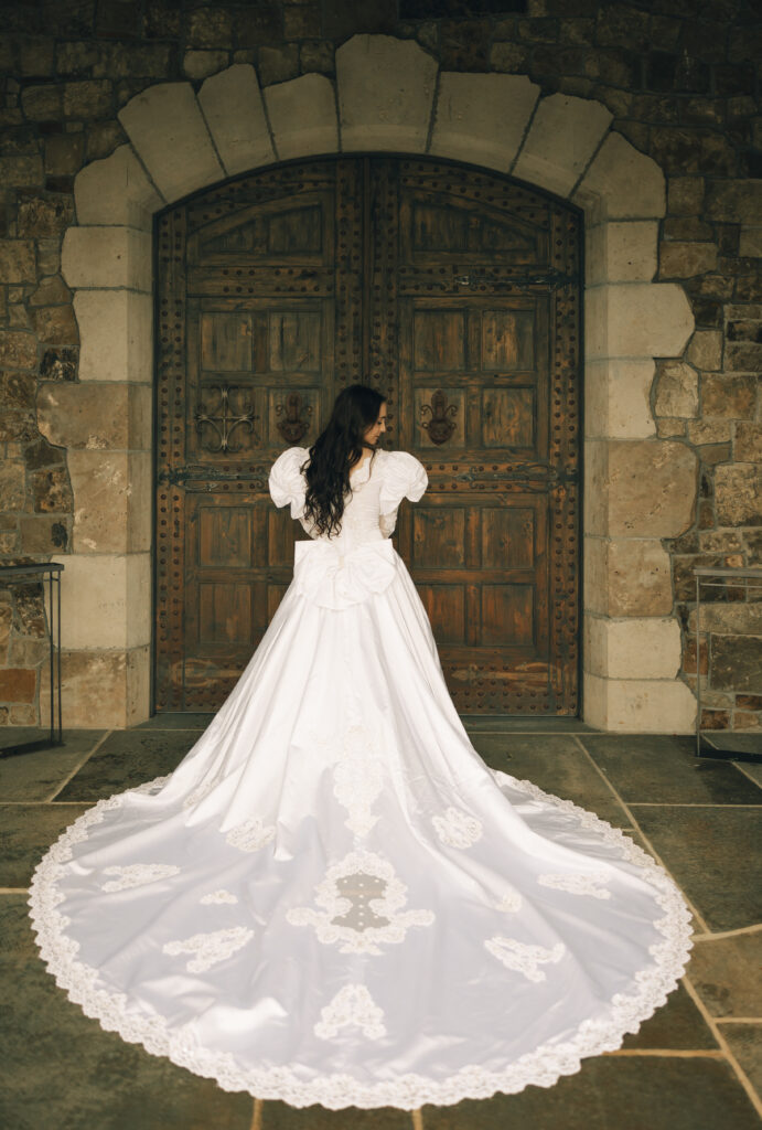 bride in front of large doors with trail laid out