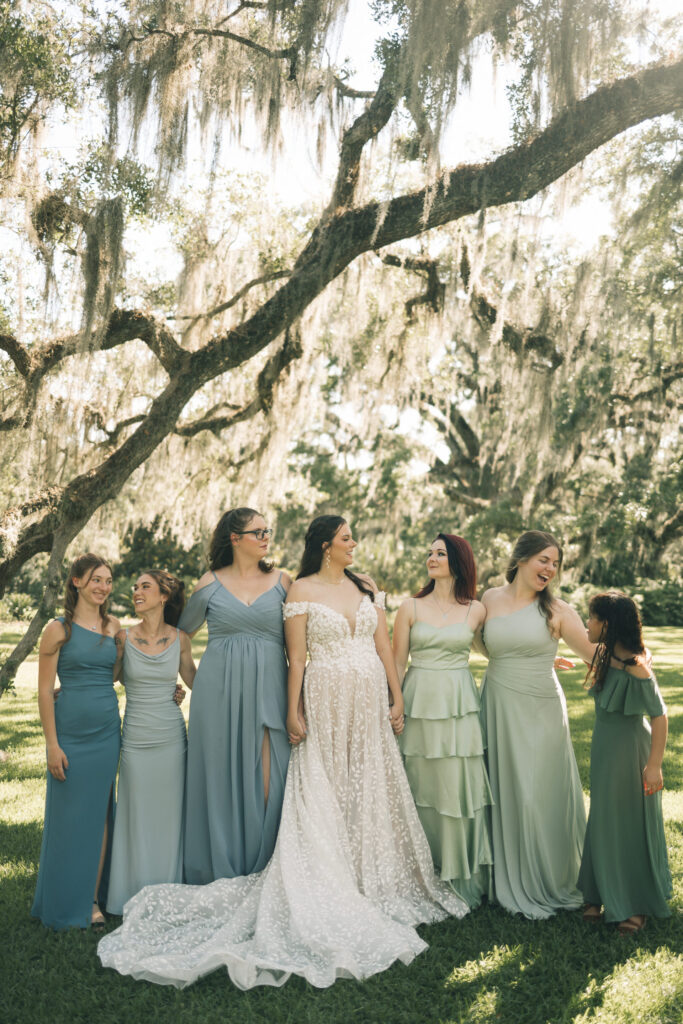 bride and bridesmaids holding hands and laughing