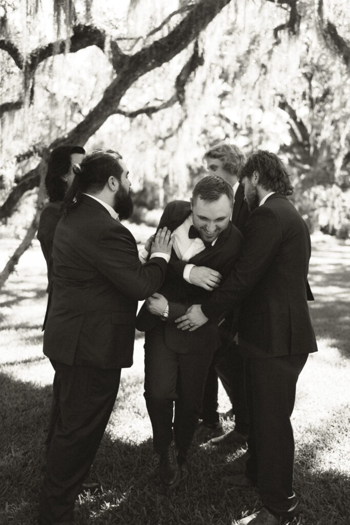 groom getting shoved by groomsmen 