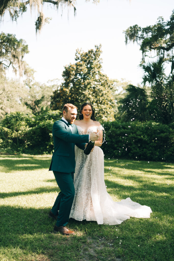 bride and groom popping champagne