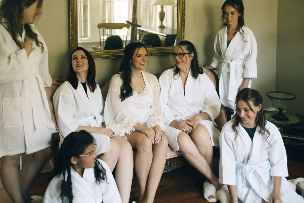 bride and bridesmaids laughing while getting ready at Goodwood Museum & Garden 