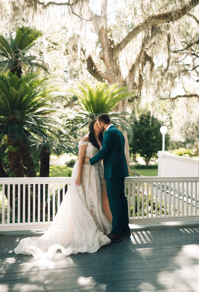 bride and groom kissing by railing