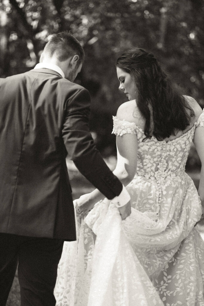 groom holding his bride's dress