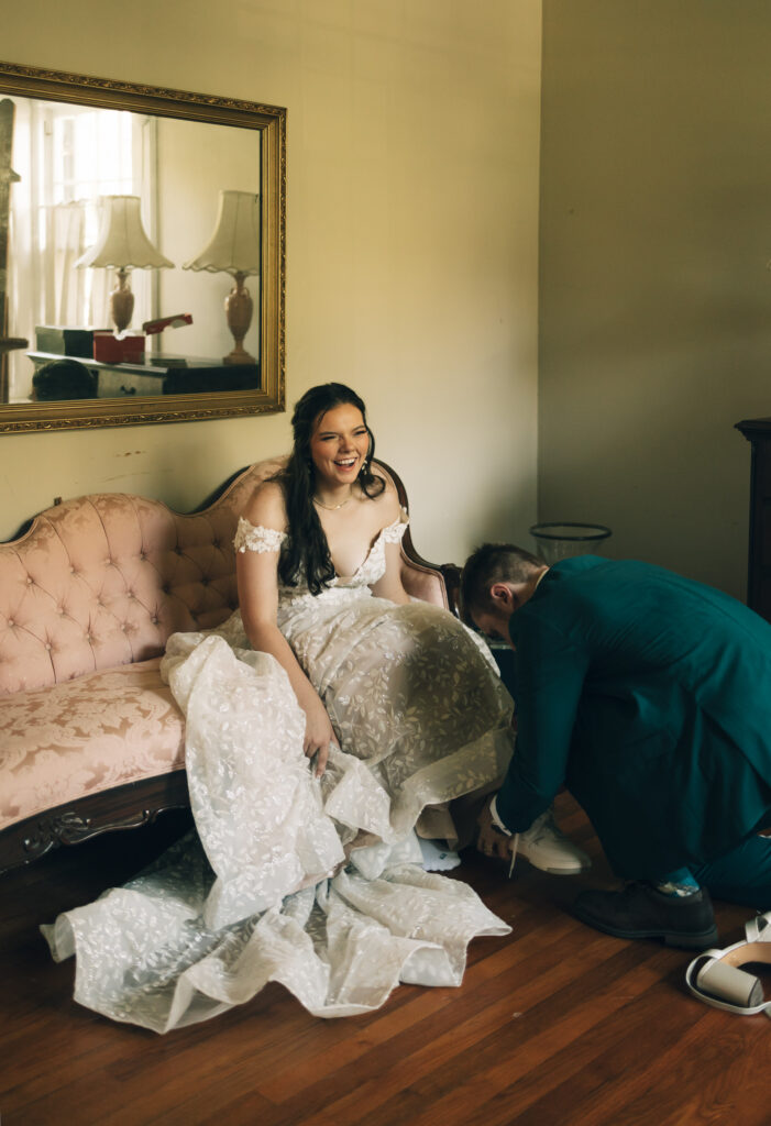 groom changing his bride's shoes