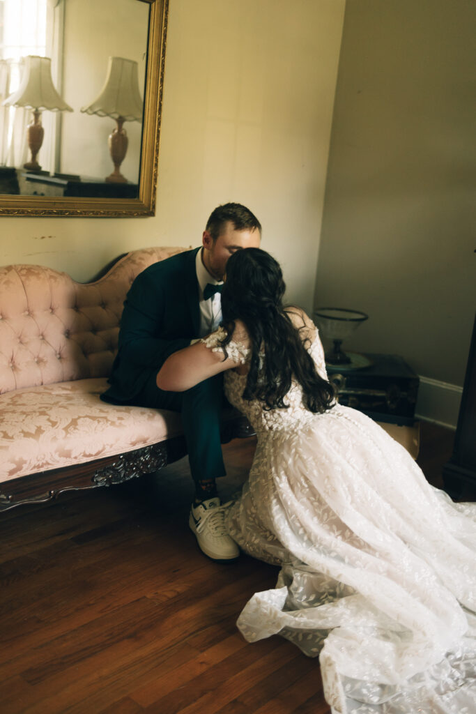 bride kissing her seated groom