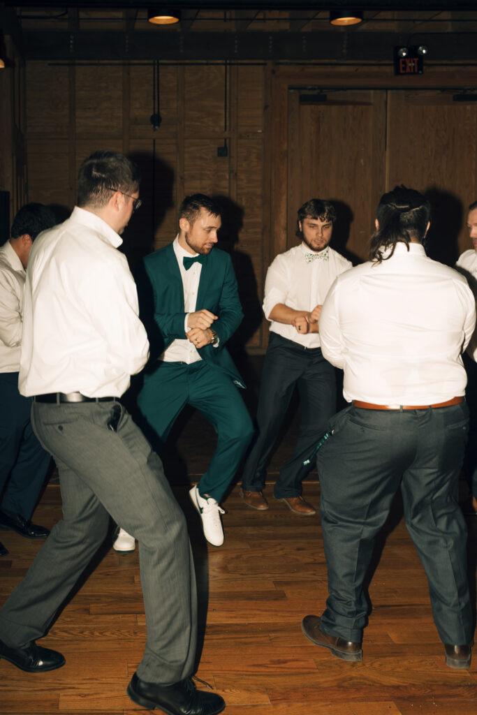 groomsmen dancing at reception at Goodwood Museum & Garden