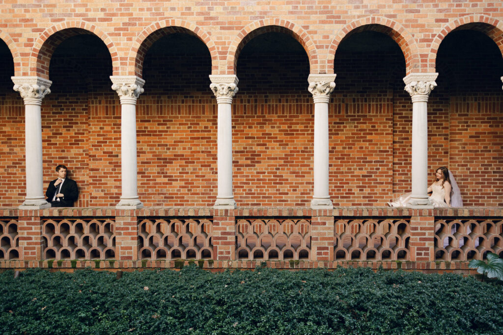 bride and groom sitting on opposite benches in museum courtyard