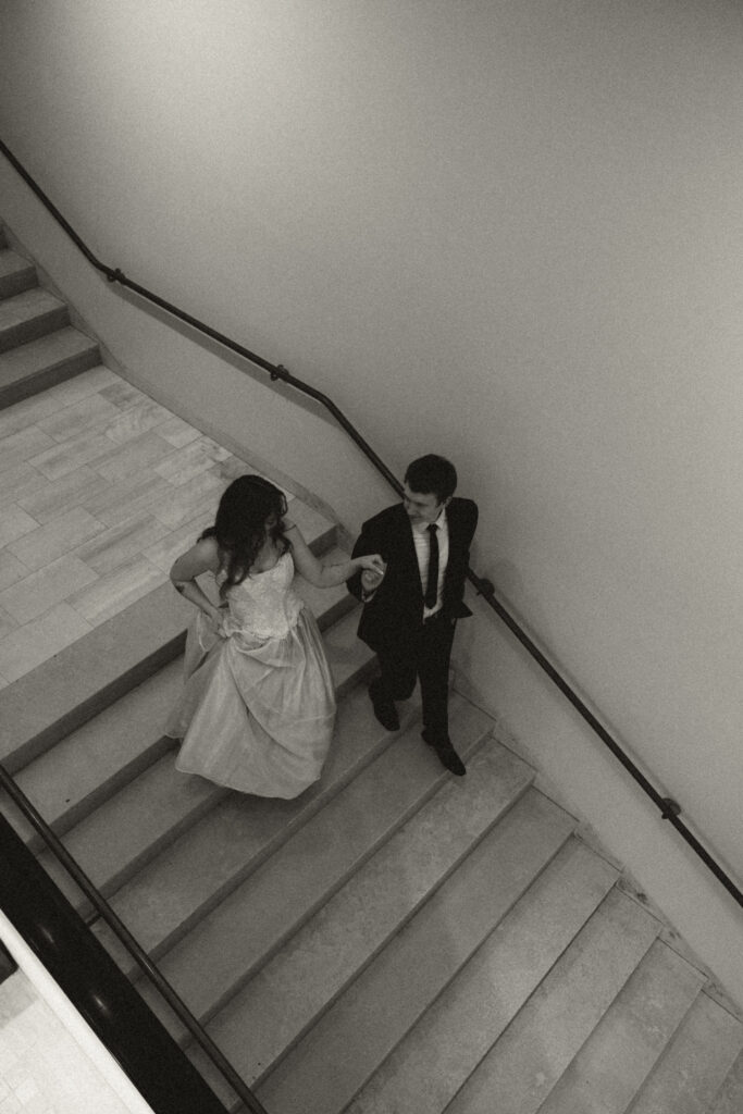 wedding couple walking down regal stairs