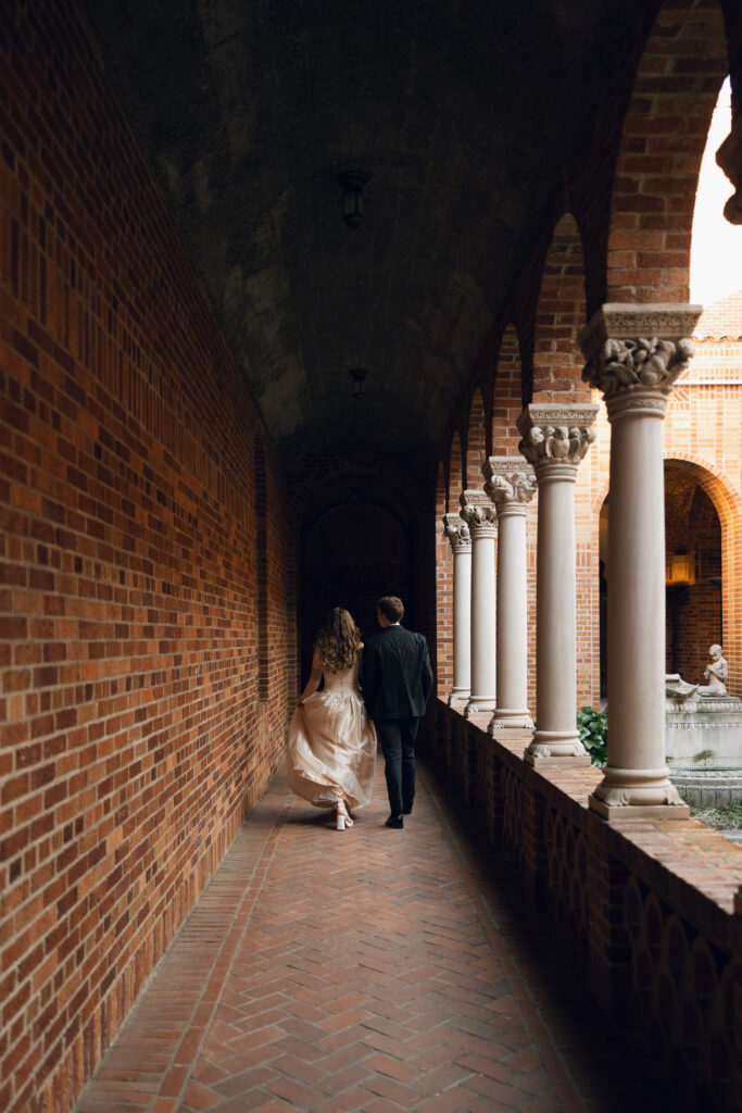 bride and groom walking away in courtyard