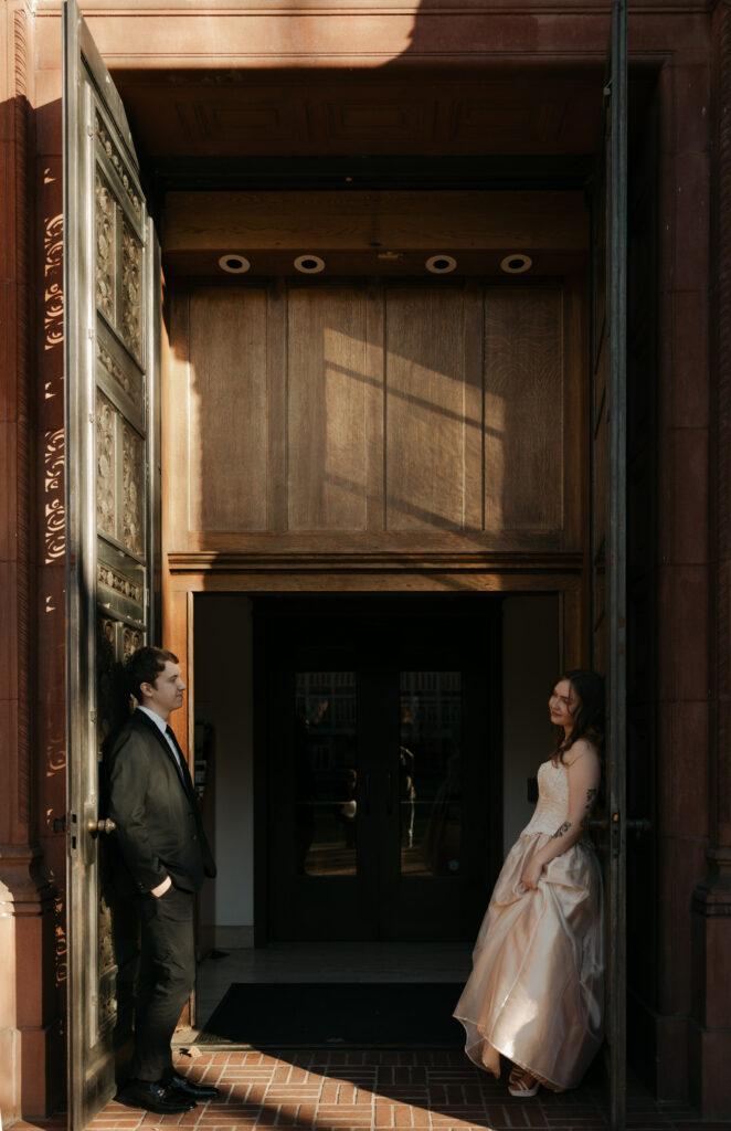 wedding couple leaning on doorway at their museum wedding