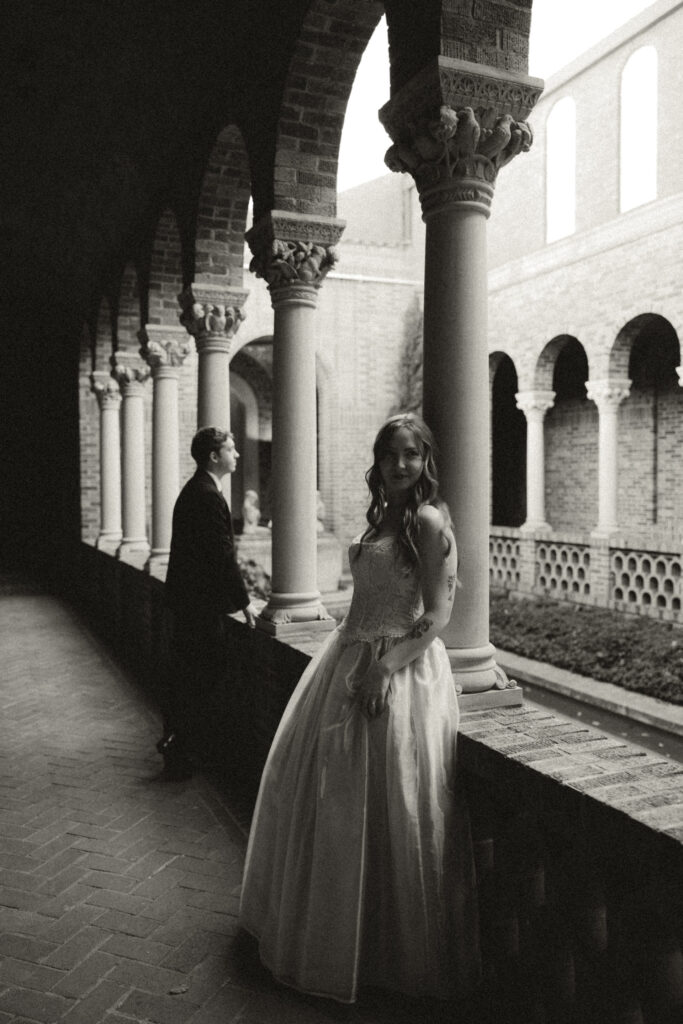 groom looking out of railing, bride facing opposite direction 