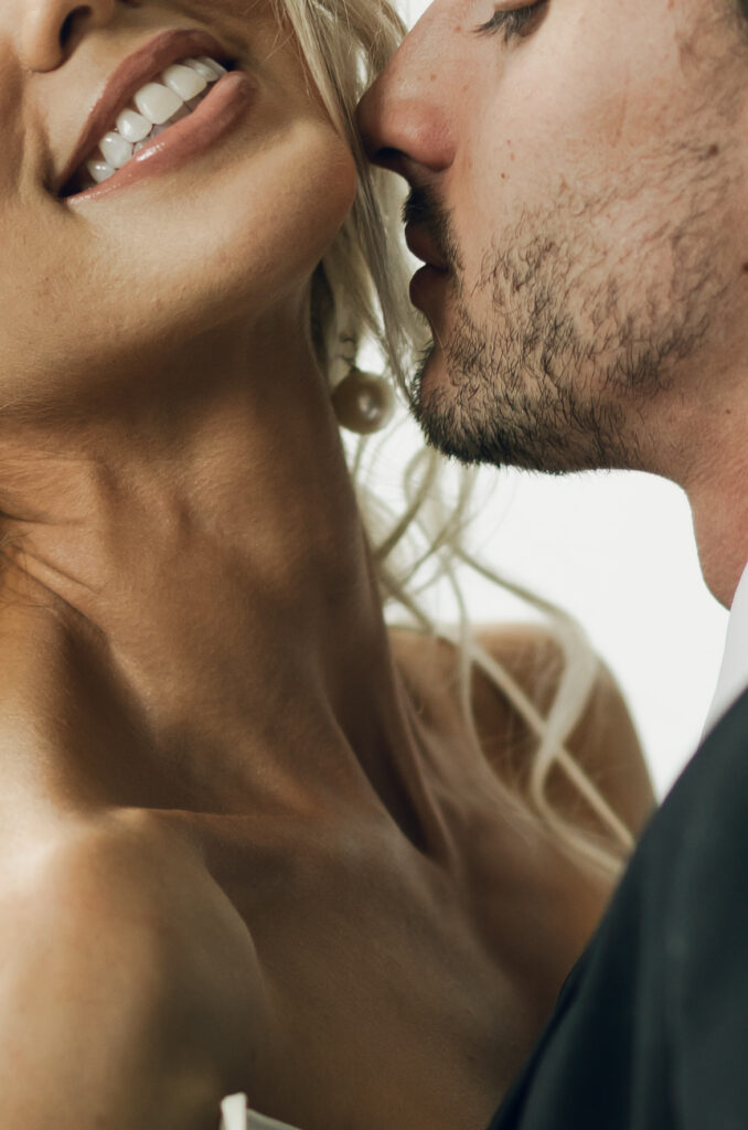 close up of groom about to kiss bride's neck