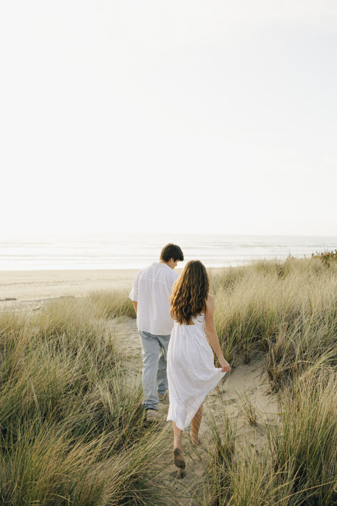 engaged couple walking through seagrass