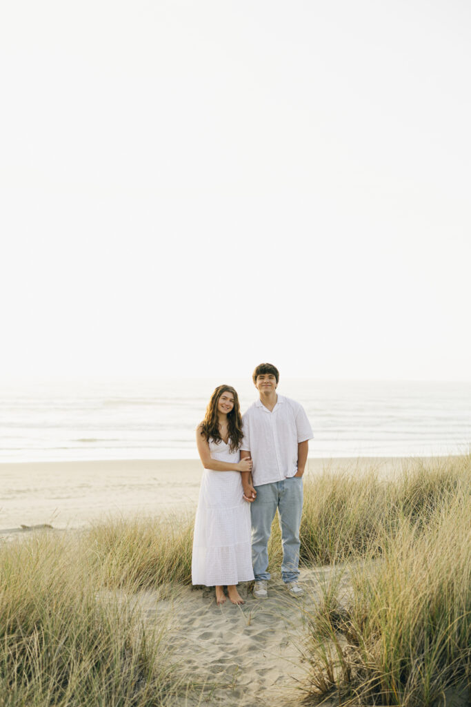 couple standing near beach and smiling at camera