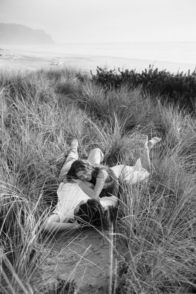 couple laying in grass during engagement photos