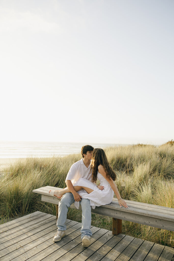 couple sitting on beach platform and kissing
