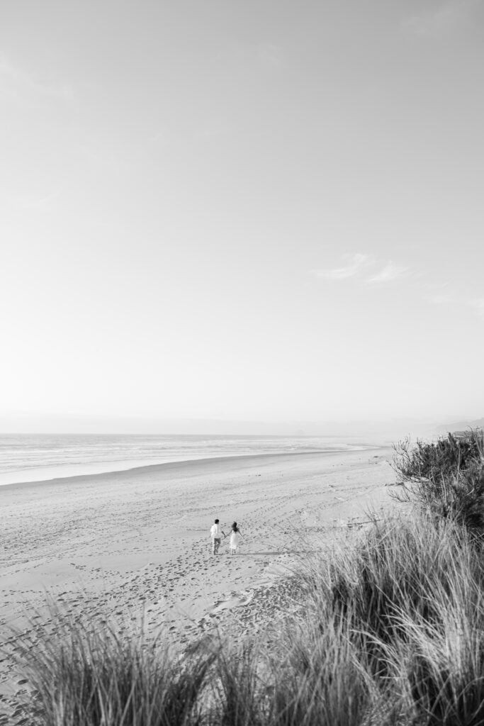 couple running on the beach during engagement photos