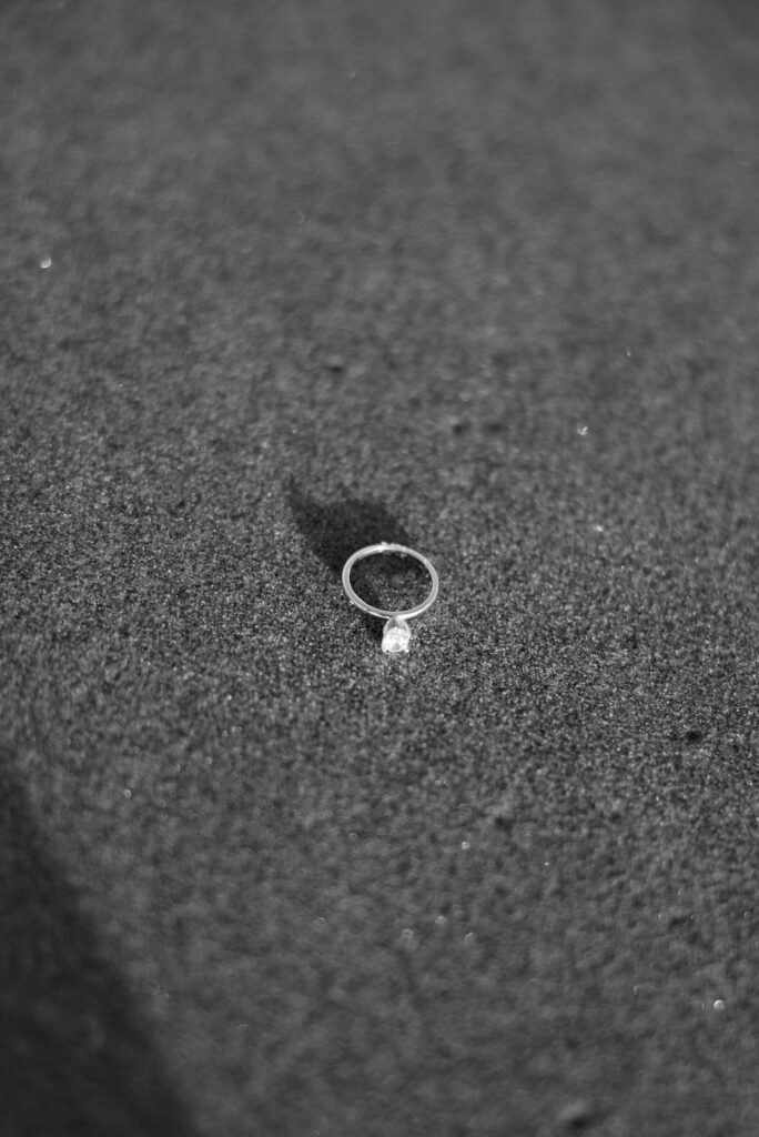 engagement ring on sand at beach