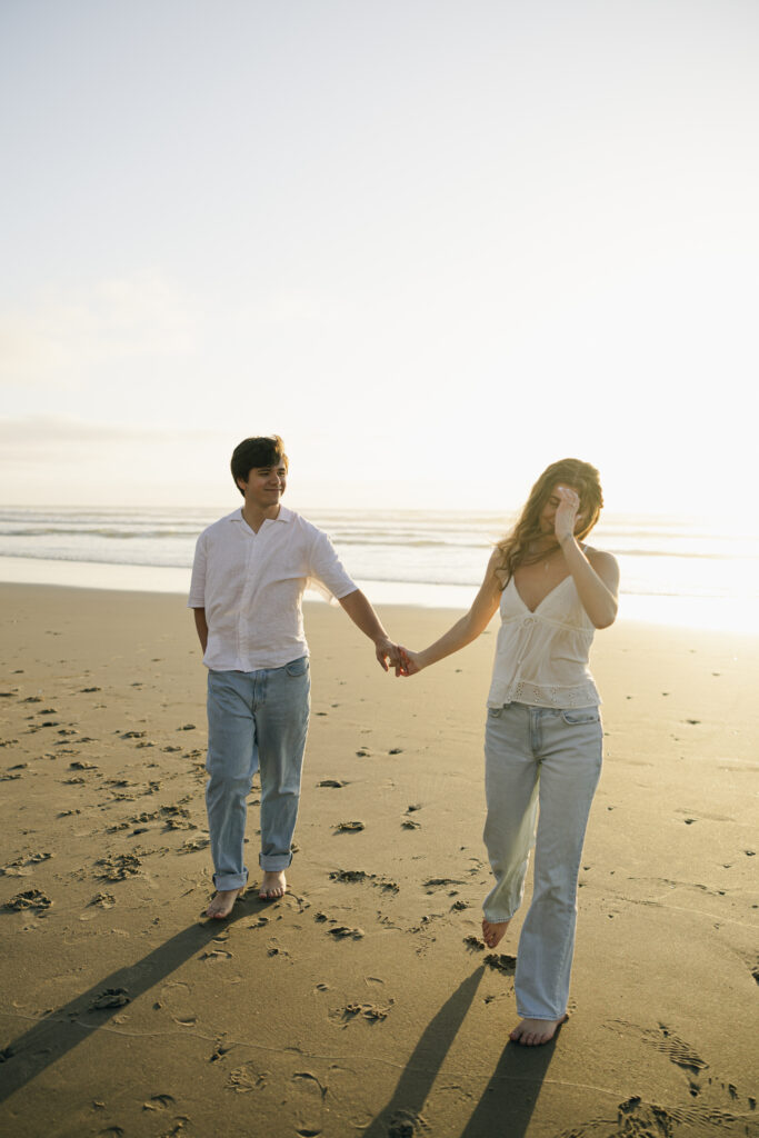 engaged couple walking toward me at beach