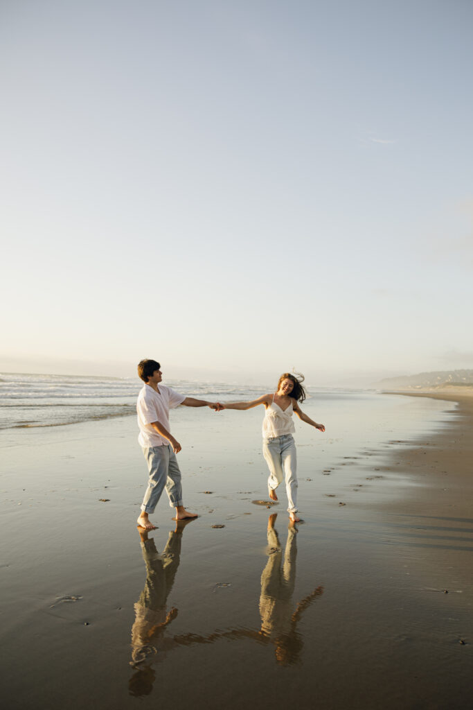 playful couple during beach engagement photos