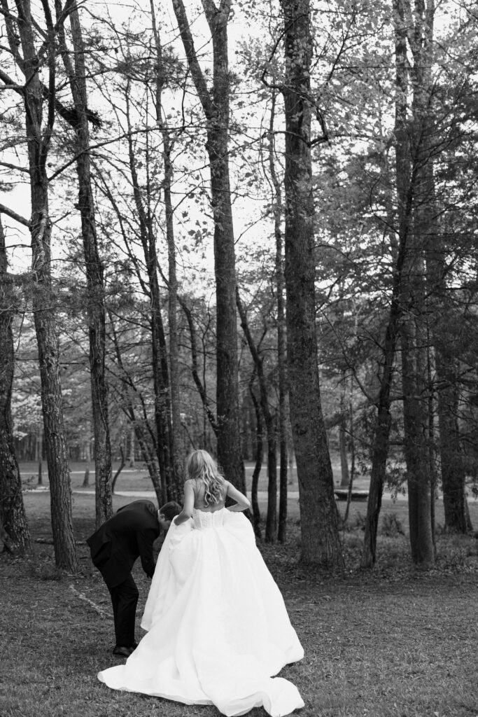 groom helping fix bride's dress for wedding photos