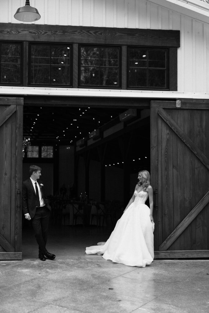 bride and groom leaning against barn doors