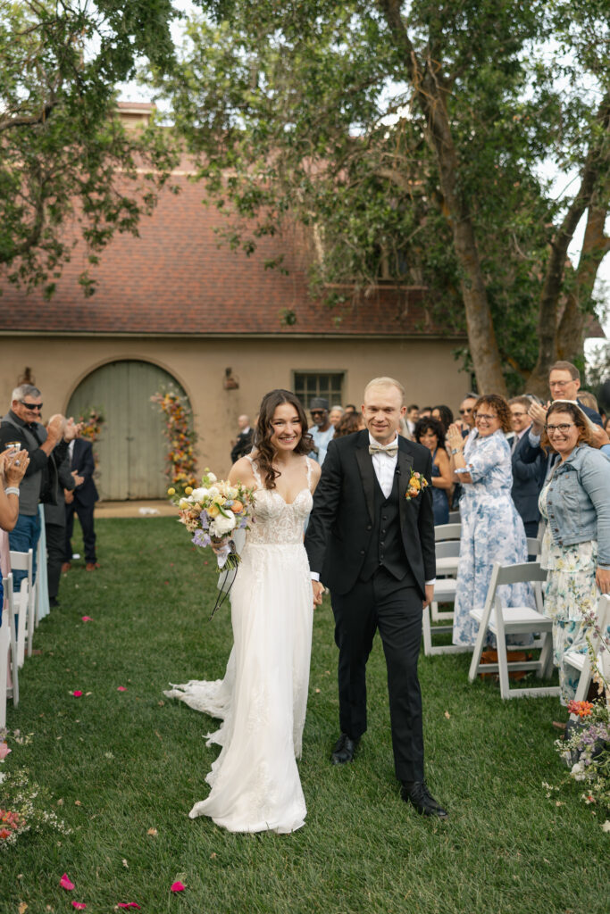 bride and groom walking down the aisle after first kiss