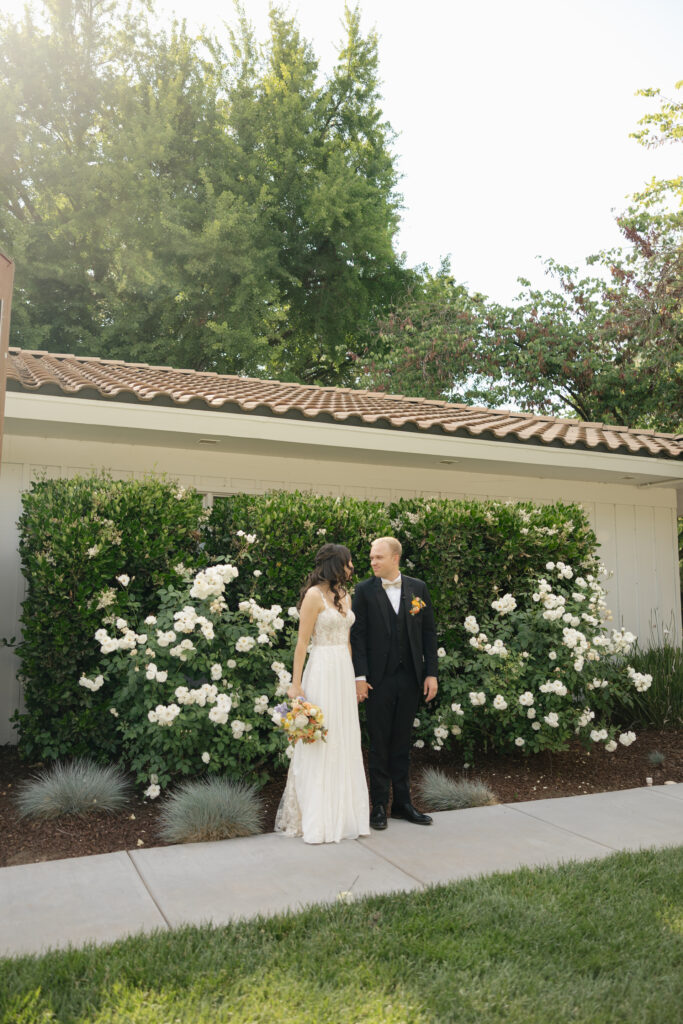 bride and groom standing side by side and looking at each other
