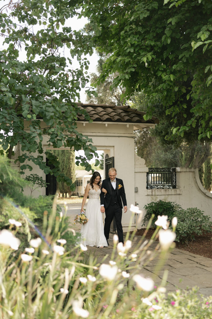 bride and groom walking through archway