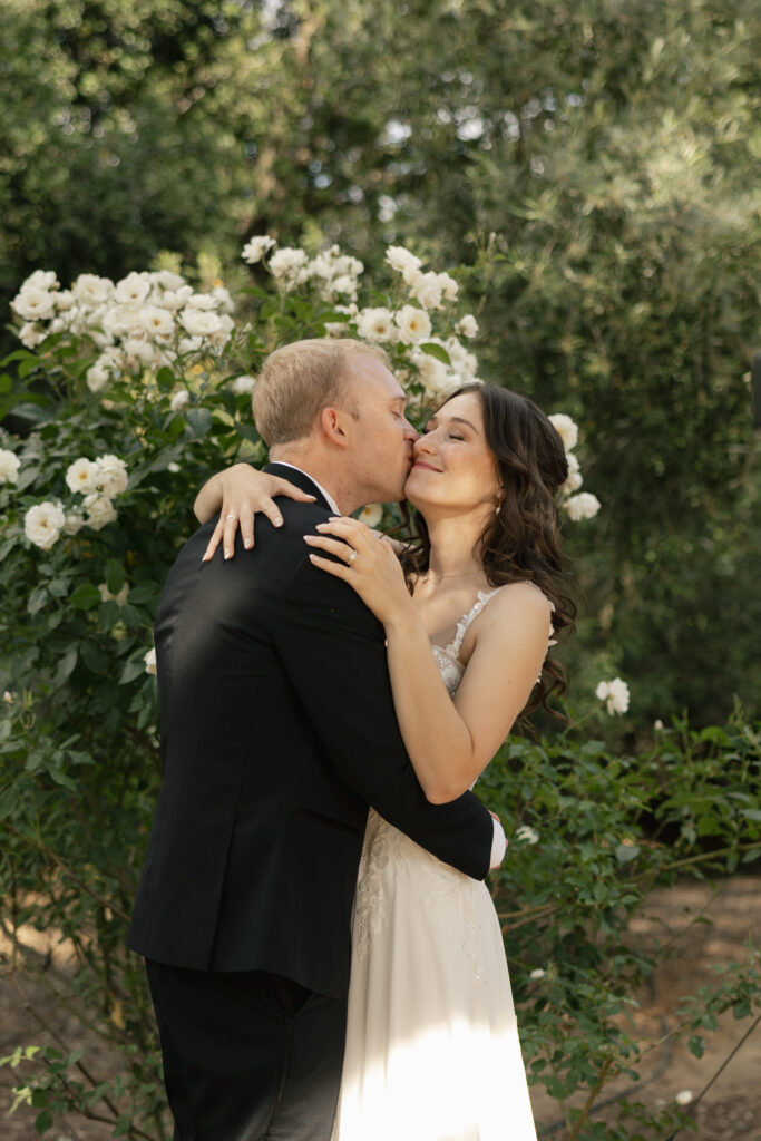 groom kissing bride on cheek