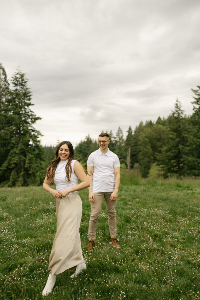woman walks away and man watches her from behind at hoyt arboretum portland