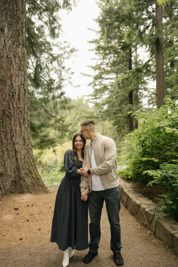 man kisses womans temple as she smiles at camera