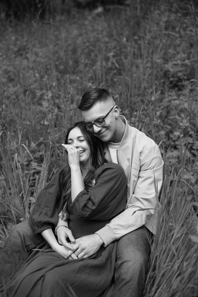 woman sits in between mans legs and leans into him