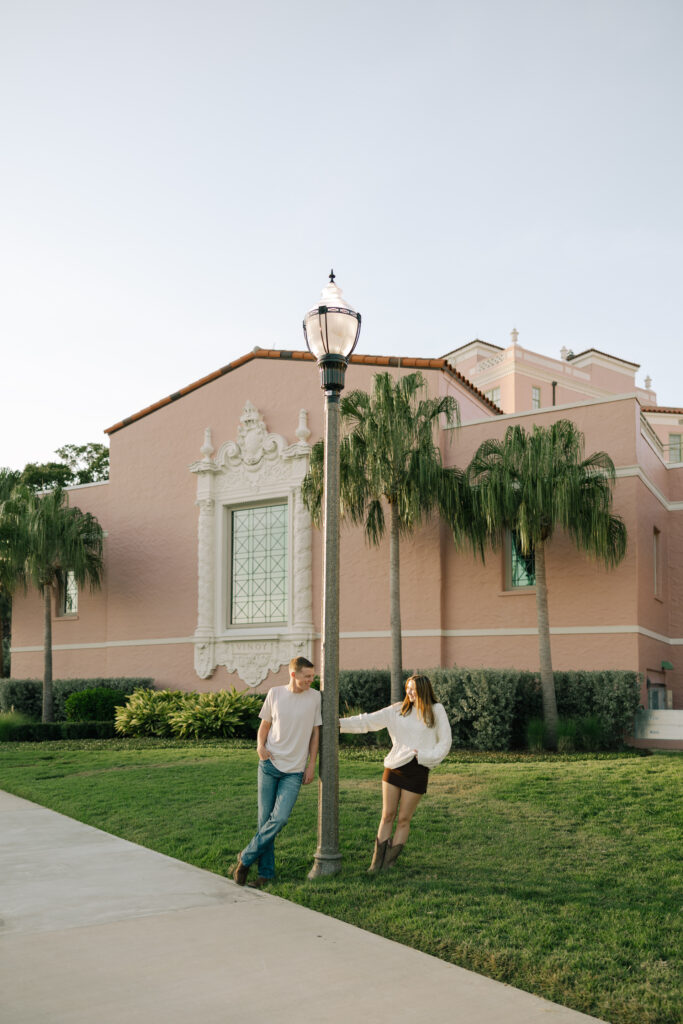guy leaning on light pole and girl leaning away in front of vinoy