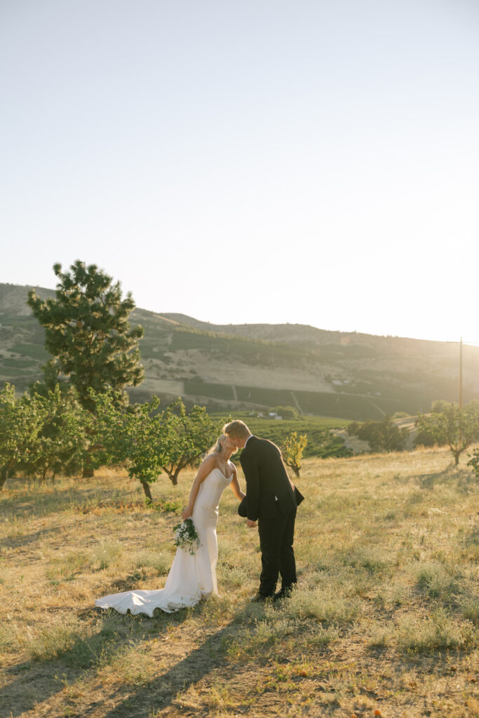 sunset wedding photos of bride and groom kissing in orchard