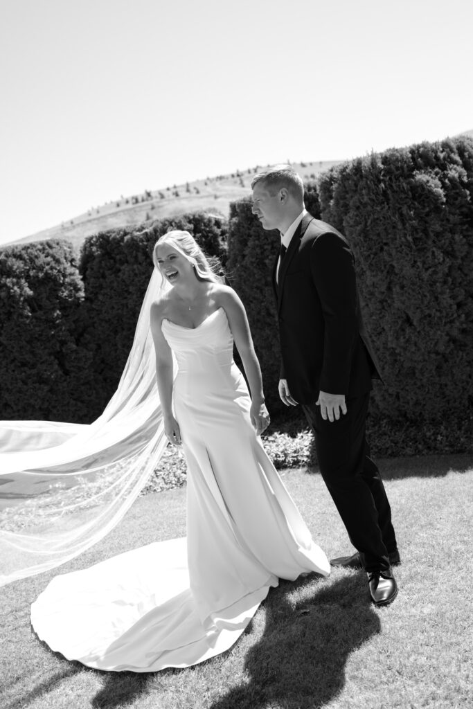 bride laughing and groom looking at her in black & white