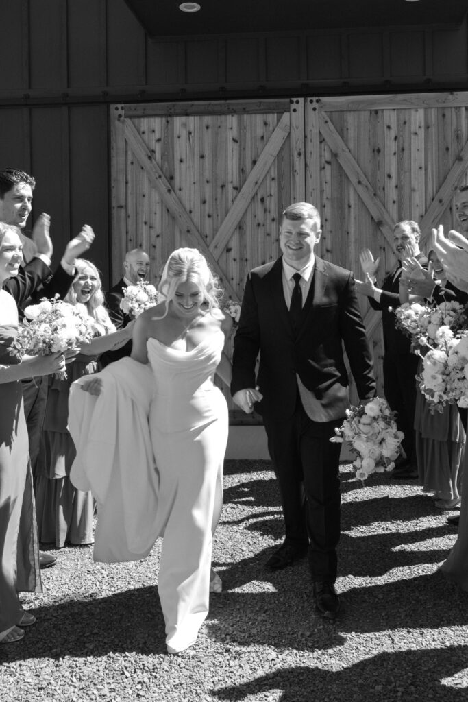 bride & groom walking through wedding party tunnel