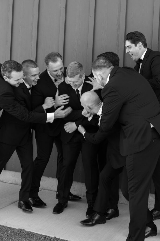 groomsmen pushing groom